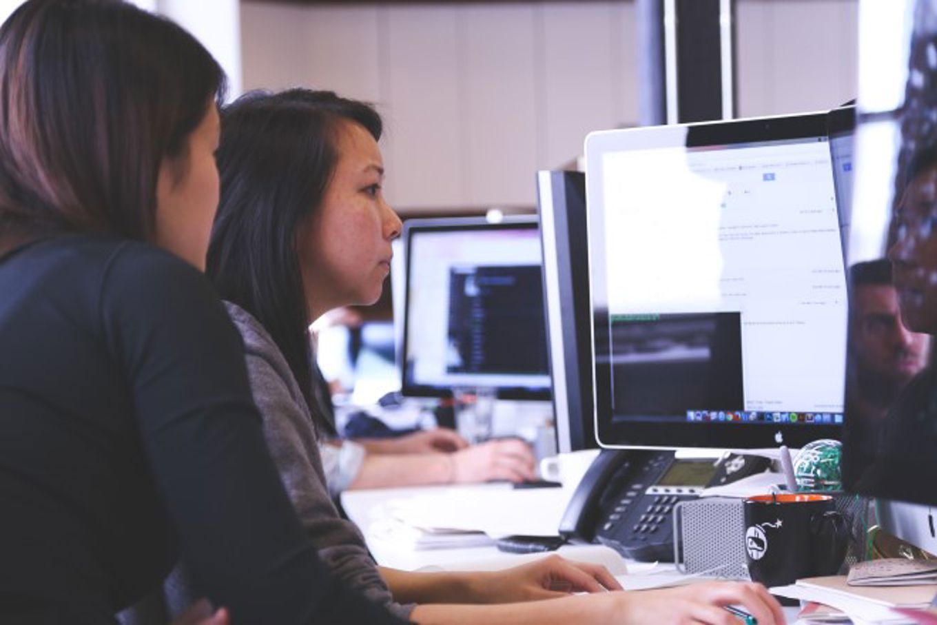 Noen få personr som jobber på datamaskiner