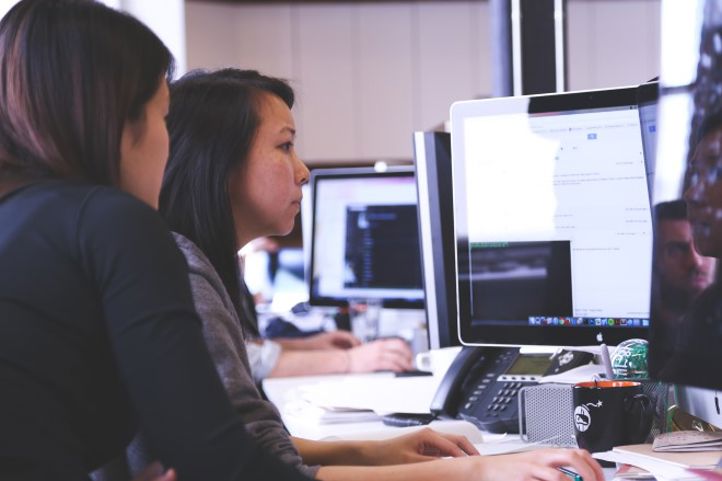 Noen få personr som jobber på datamaskiner